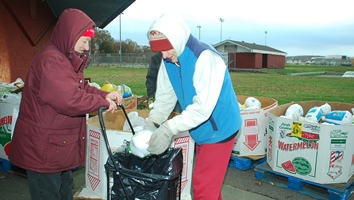 Volunteer helps distribute a Thanksgiving turkey