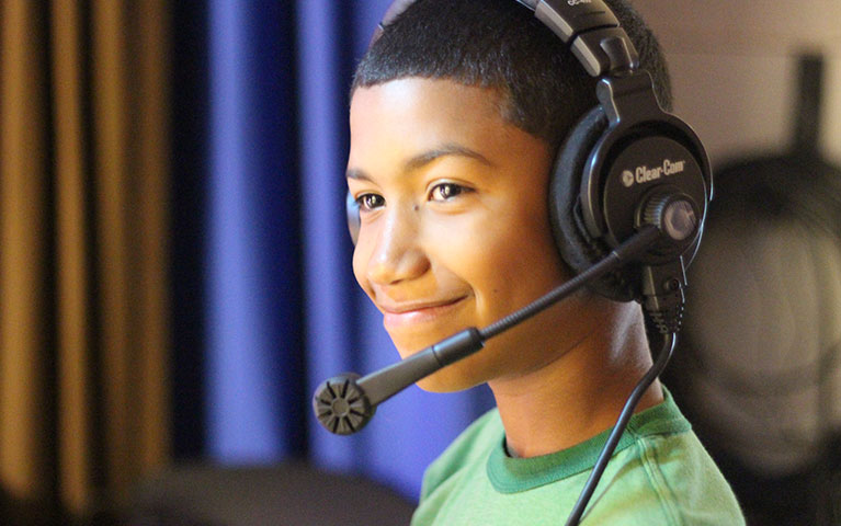 Young boy smiling and wearing a TV headset